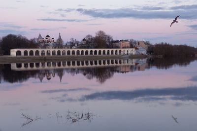 Reflection of trees in river against cloudy sky