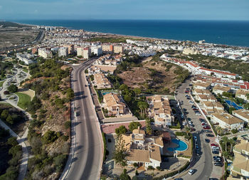 High angle view of city by sea against sky