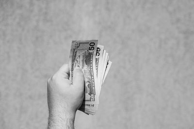 Cropped hand of woman holding paper currency