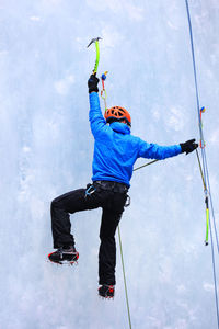 Rear view of man ice climbing