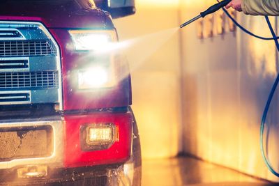 Cropped hand washing car in garage