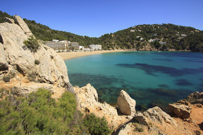 Scenic view of rocky mountains and sea against clear sky