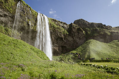 Scenic view of waterfall against sky