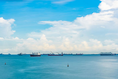 View of boats in sea against cloudy sky