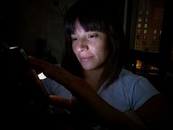 Woman using smart phone at night