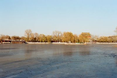 Scenic view of lake against clear sky during winter