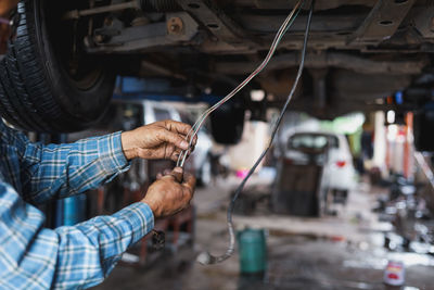 Midsection of mechanic working at workshop