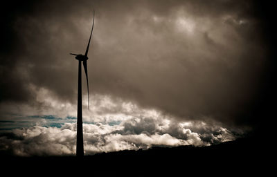 Low angle view of silhouette crane against sky