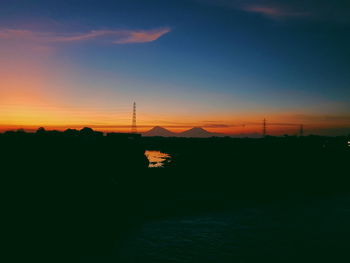 Scenic view of silhouette mountains against orange sky