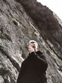 Low angle view of man standing on rock