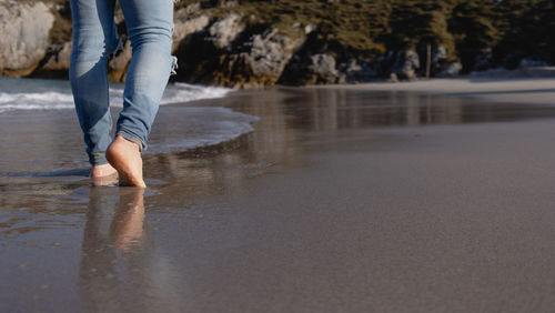 Man walking barefoot on the beach