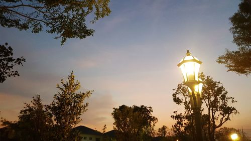 Low angle view of illuminated street light against sky during sunset