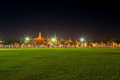 Illuminated buildings against sky at night