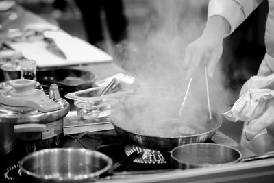 Midsection of man preparing food in commercial kitchen