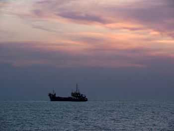 Silhouette ship sailing on sea against sky during sunset