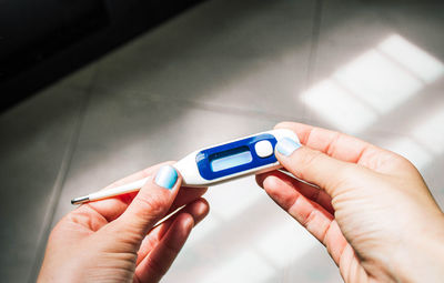 Female hands holding a thermometer