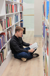 Side view of man using mobile phone in library