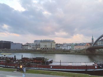 Barge moored on river vistula against cloudy sky