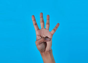 Close-up of human hand against blue background