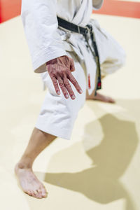 Mature man practicing karate on floor in health club