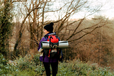 Backpacker trekking in autumn forest