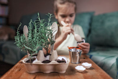 Midsection of boy sitting on table at home