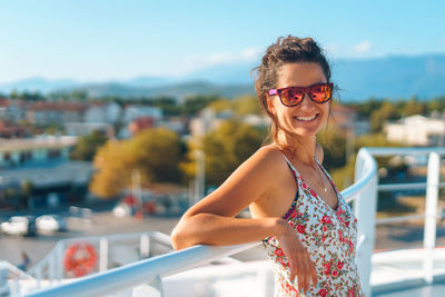 Smiling young woman standing in balcony