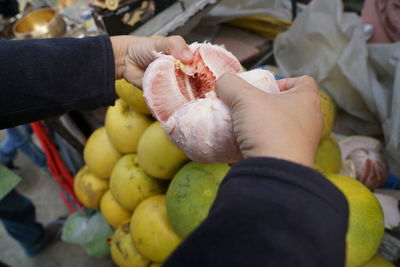 Midsection of person holding fruits at market