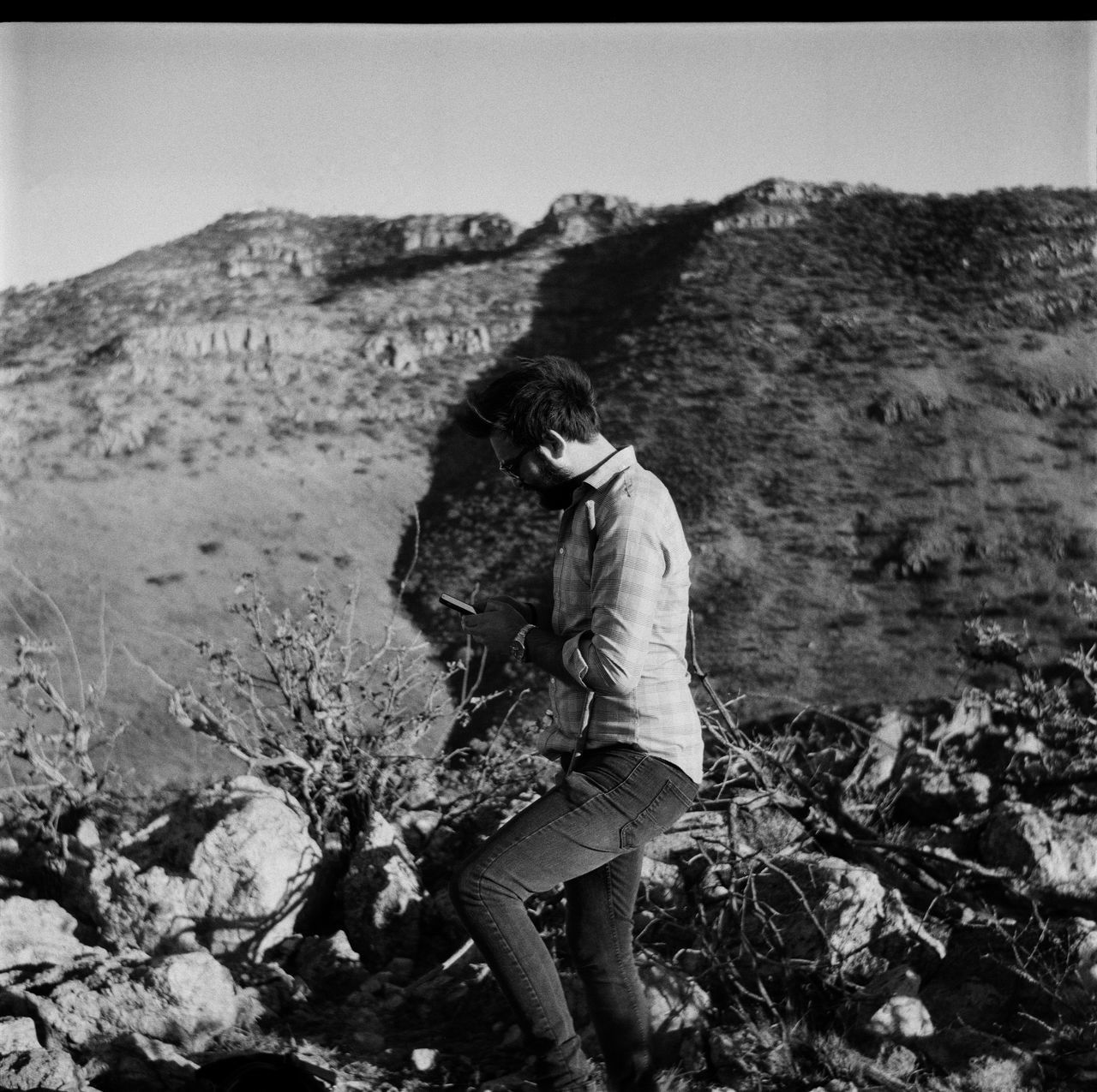 MAN STANDING ON ROCK IN SUNLIGHT