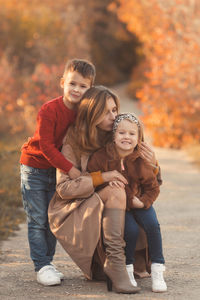 Portrait of smiling girl with arms raised during autumn