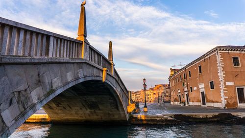 Bridge over river against buildings