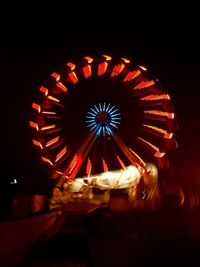 Low angle view of illuminated ferris wheel against sky at night