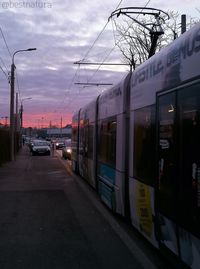 Train at railroad station in city against sky