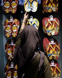 Rear view of woman hijab at sandals store