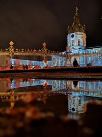 Reflection of illuminated building in water at night