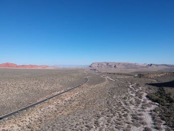 Scenic view of desert against clear blue sky