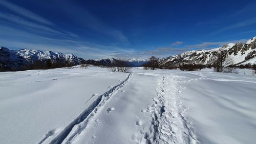 Scenic view of snow covered field against sky