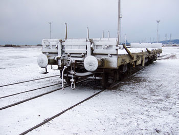 Boats on snow covered field against sky