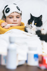 Sick child boy cat digital thermometer fever illness headache in hospital temperature health pills 