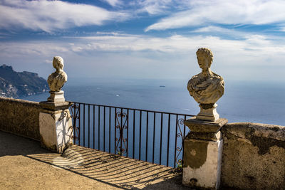 Statue by sea against sky