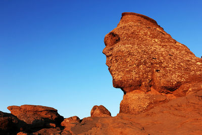 Sphinx rock formation against clear blue sky at bucegi natural park