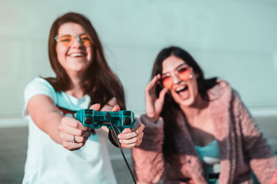 Cheerful young women playing with joystick