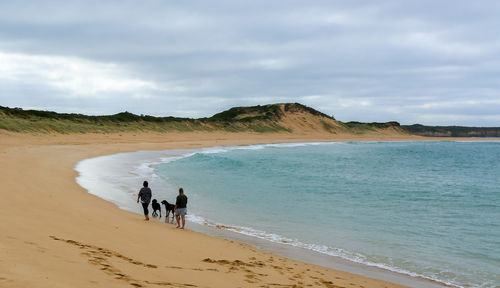 People on beach against sky