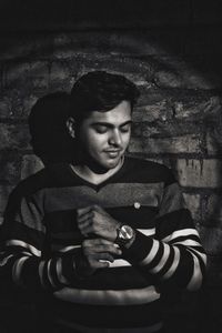 Portrait of teenage girl sitting against wall