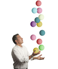 Low angle view of man with balloons against white background