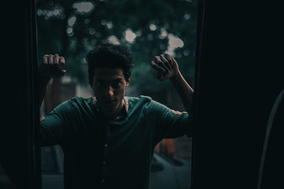 Young man looking through window