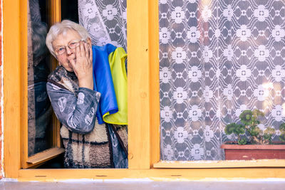 Portrait of woman standing by window