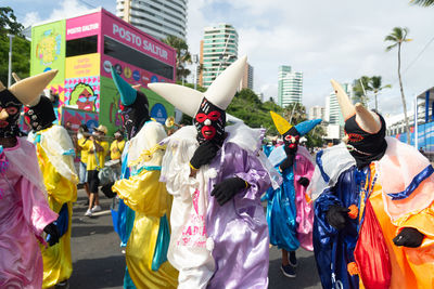 Group of masked and costumed people parade in fuzue, pre-carnival in salvador, bahia, brazil.