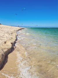 Scenic view of beach against blue sky