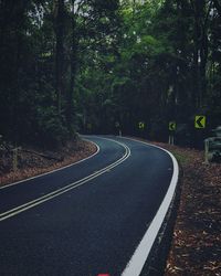 Empty road amidst trees in forest